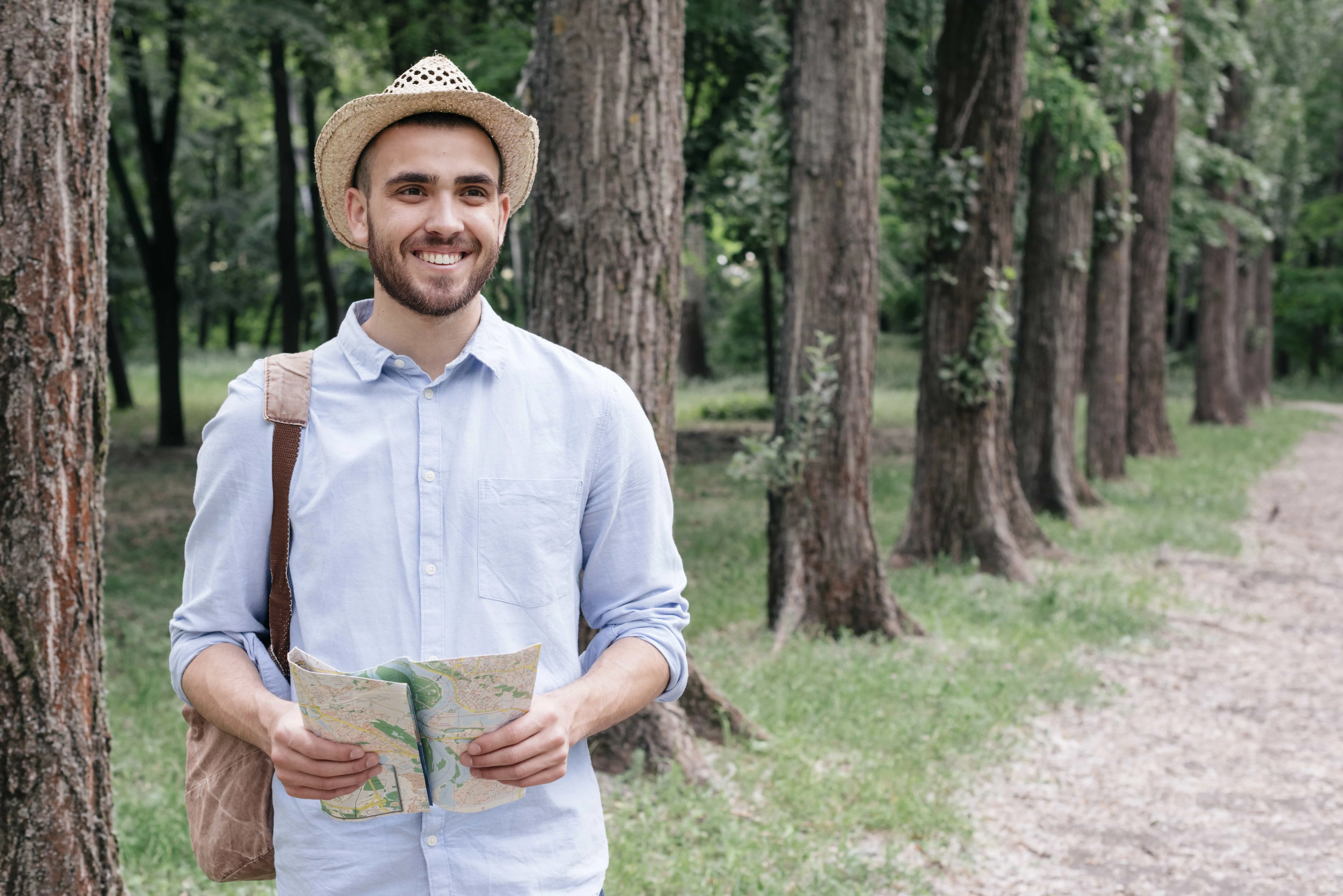 smiling-young-man-wearing-hat-holding-map-park.jpg